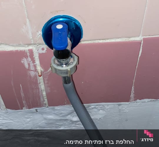 ברז מים עם צינור מחובר לקיר